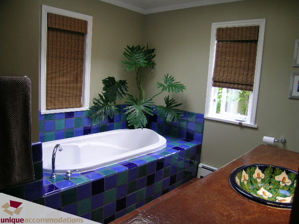 Bathroom with mosaic tile surround, greenery, and wooden blinds. - 1385 East 15th Street, North Vancouver