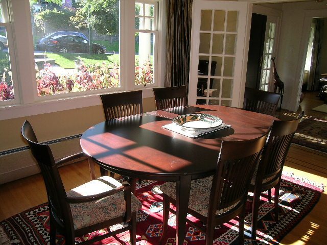 Dining room with large windows, hardwood floors, and a patterned rug. - 4663 Bellevue Drive, Vancouver West Side
