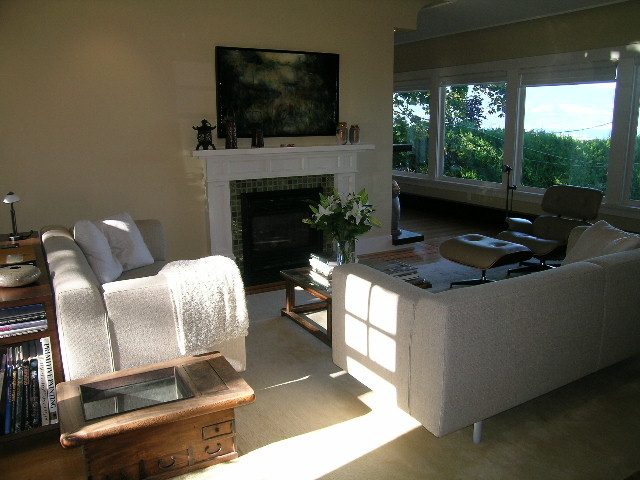 Bright living room with a fireplace, large windows, and a cozy sofa. - 4663 Bellevue Drive, Vancouver West Side