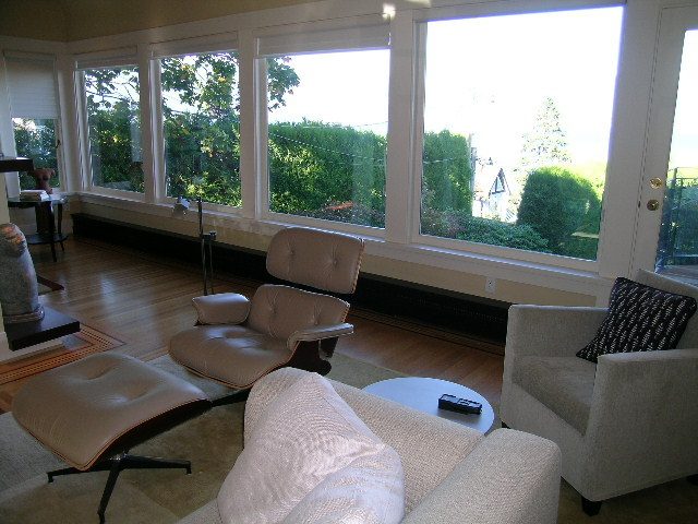 Bright sunroom with large windows, hardwood floors, and a cozy corner seating area. - 4663 Bellevue Drive, Vancouver West Side