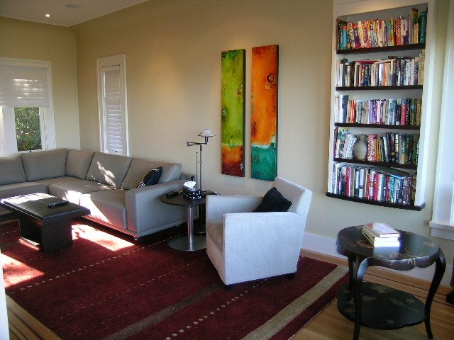 Spacious living room with a large sectional sofa, bookshelf, and vibrant wall art. - 4663 Bellevue Drive, Vancouver West Side