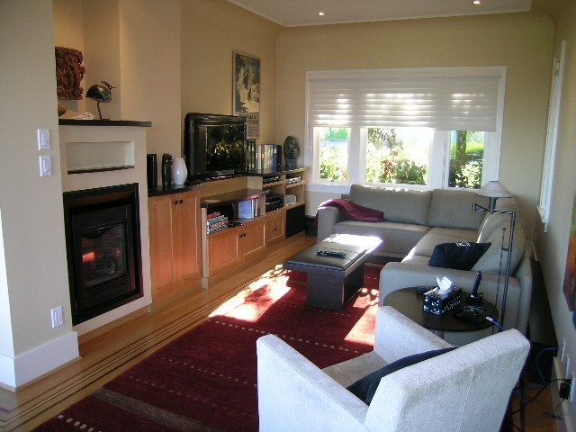 Spacious living room with hardwood floors, a fireplace, and large windows letting in natural light. - 4663 Bellevue Drive, Vancouver West Side