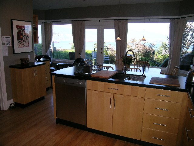 Bright kitchen with hardwood floors, city view, and modern cabinetry. - 4663 Bellevue Drive, Vancouver West Side