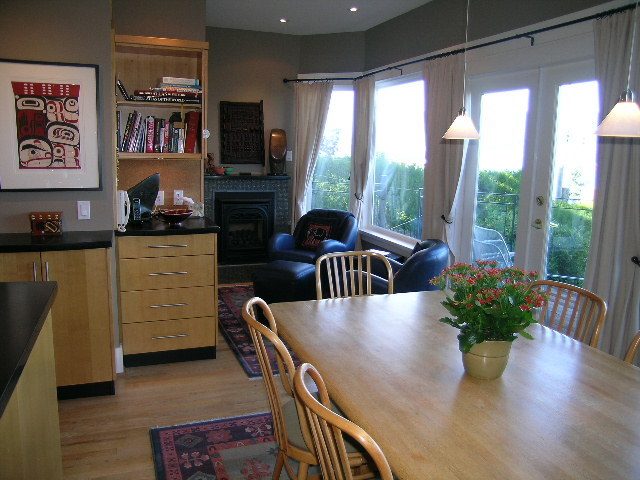 Dining area with wooden table, chairs, and large windows. - 4663 Bellevue Drive, Vancouver West Side