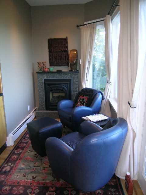 Living room with blue leather chairs, patterned rug, and fireplace. - 4663 Bellevue Drive, Vancouver West Side