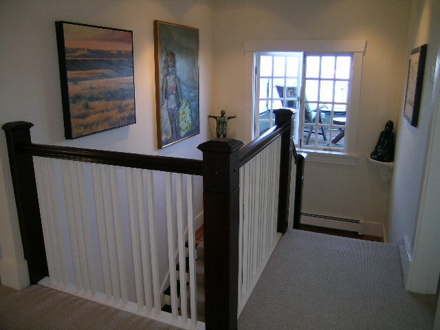 Staircase leading to upper level with framed artwork and window view. - 4663 Bellevue Drive, Vancouver West Side