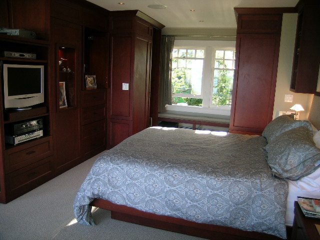 Spacious bedroom with wooden furniture, large window, and neatly made bed. - 4663 Bellevue Drive, Vancouver West Side