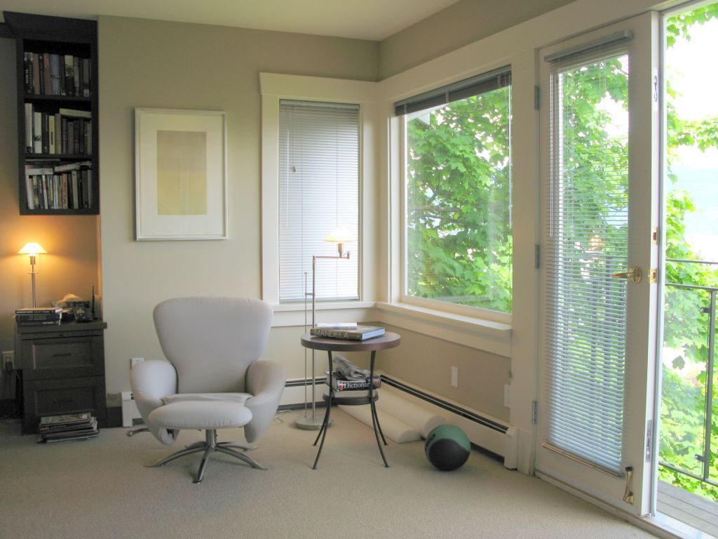 Bright sunroom with large windows, cozy armchair, and outdoor view. - 4663 Bellevue Drive, Vancouver West Side