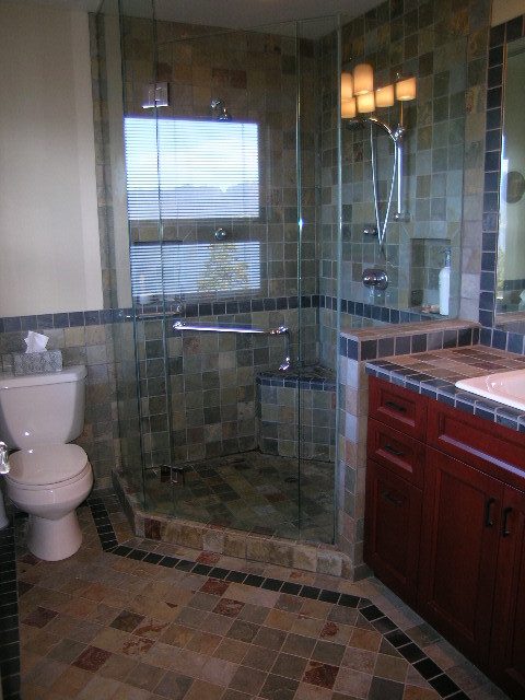 Bathroom with glass shower, tiled walls, and wooden cabinets. - 4663 Bellevue Drive, Vancouver West Side