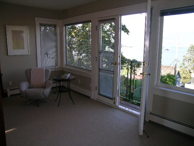 Bright living room with large windows, city view, and cozy seating. - 4663 Bellevue Drive, Vancouver West Side
