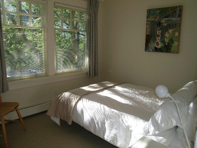 Bright bedroom with large windows, natural light, and a cozy bed setup. - 4663 Bellevue Drive, Vancouver West Side