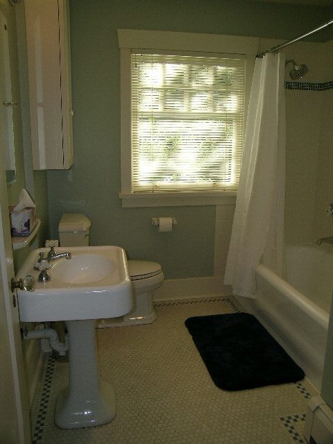 Bathroom with pedestal sink, shower, and black bath mat. - 4663 Bellevue Drive, Vancouver West Side