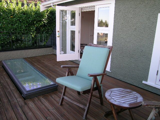 Furnished patio with wooden deck, glass sliding doors, and outdoor furniture. - 4663 Bellevue Drive, Vancouver West Side