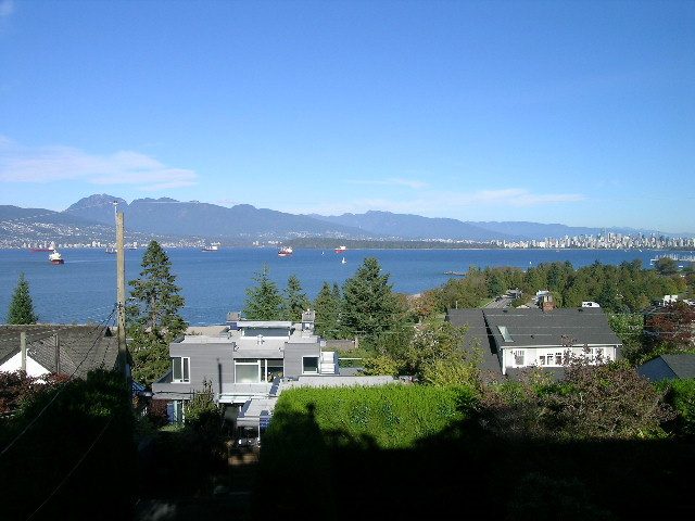 Bright living room with a stunning city view and lush greenery. - 4663 Bellevue Drive, Vancouver West Side