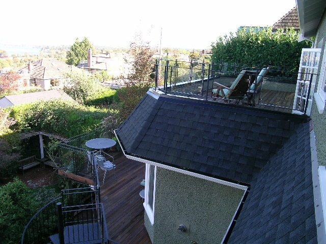Bright rooftop deck with wooden flooring, greenery, and city view. - 4663 Bellevue Drive, Vancouver West Side