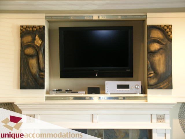 Living room with a modern TV setup and decorative wall art. - 3030 West 15th Avenue, Vancouver West Side