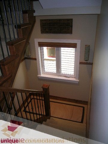 Staircase leading to upper level with wooden banister and window above. - 3030 West 15th Avenue, Vancouver West Side