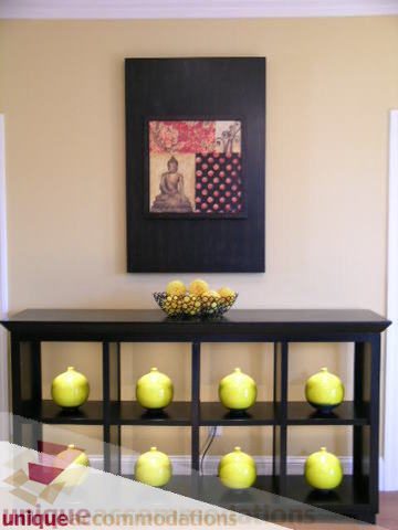 Bright living room with black shelves, yellow decor, and a Buddha painting. - 3030 West 15th Avenue, Vancouver West Side