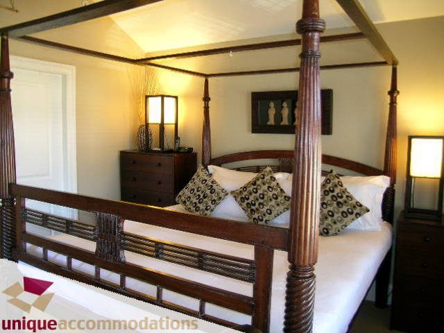 Spacious bedroom with four-poster bed, wooden furniture, and decorative pillows. - 3030 West 15th Avenue, Vancouver West Side