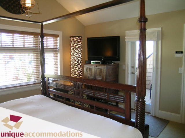 Spacious bedroom with four-poster bed, wooden accents, and large window with blinds. - 3030 West 15th Avenue, Vancouver West Side