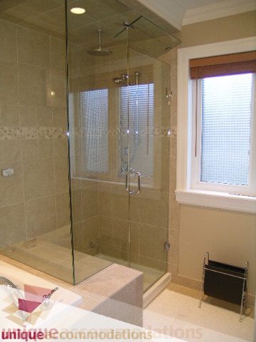 Bright bathroom with glass shower, beige tiles, and a window. - 3030 West 15th Avenue, Vancouver West Side