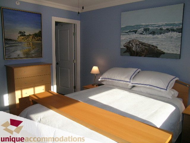 Bright bedroom with two twin beds, ocean artwork, and natural light streaming in. - 3030 West 15th Avenue, Vancouver West Side