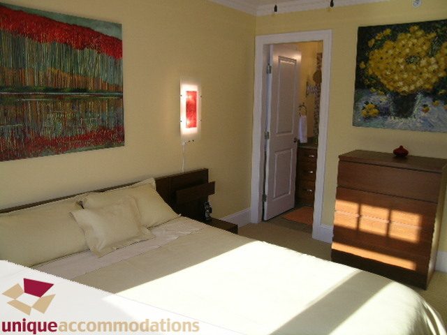 Bright living room with large windows, hardwood floors, and colorful artwork. - 3030 West 15th Avenue, Vancouver West Side