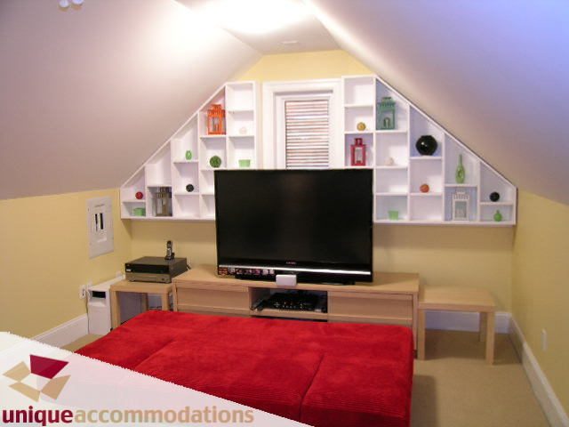 Furnished den with built-in shelves, red rug, and wooden desk. - 3030 West 15th Avenue, Vancouver West Side