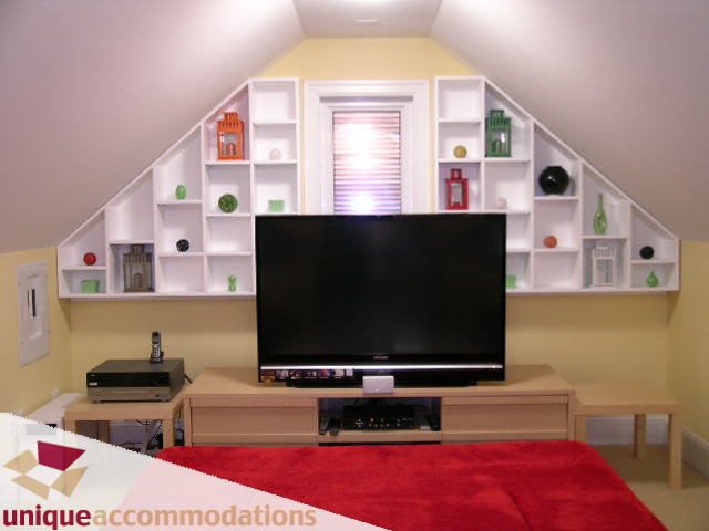 Bright living room with sloped ceiling, built-in shelves, and a red rug. - 3030 West 15th Avenue, Vancouver West Side