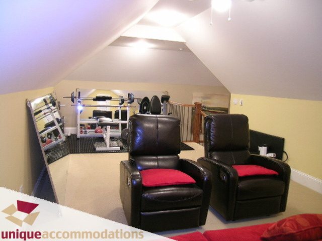 Attic space with workout equipment, leather chairs, and red cushions. - 3030 West 15th Avenue, Vancouver West Side