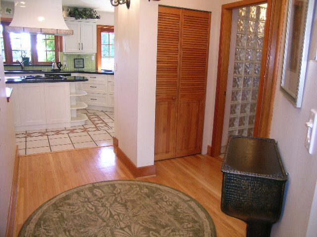 Bright kitchen with white cabinets, black countertops, and hardwood floors. - 2148 Kings Ave, West Vancouver