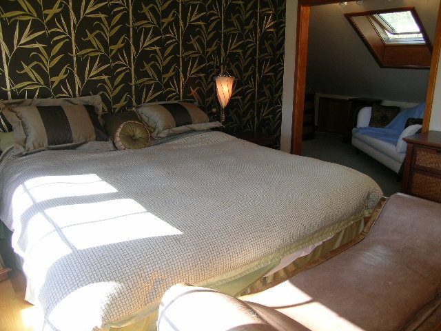 Cozy bedroom with patterned wallpaper and a neatly made bed. - 2148 Kings Ave, West Vancouver