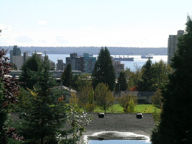 Panoramic view of the city and water, with lush greenery in the foreground. - 2148 Kings Ave, West Vancouver