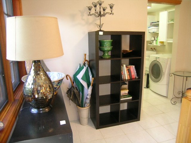 Bright living room with modern decor, black shelving unit, and a cozy lamp. - 2148 Kings Ave, West Vancouver
