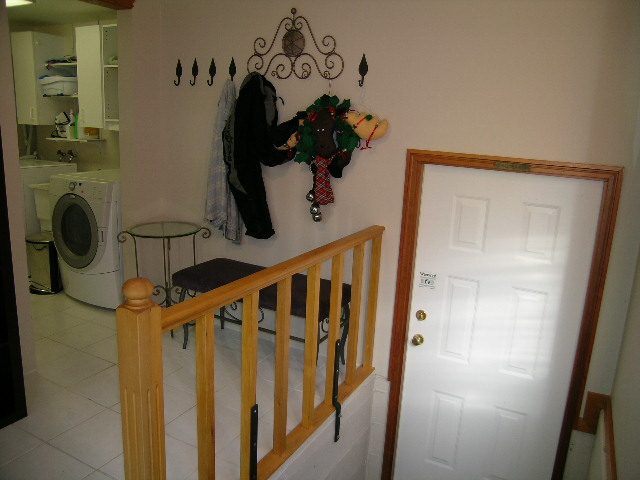 Entryway with coat rack, laundry area, and white door. - 2148 Kings Ave, West Vancouver