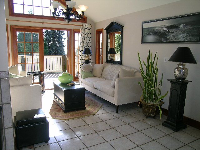 Spacious living room with large windows, tiled floor, and modern decor. - 2148 Kings Ave, West Vancouver