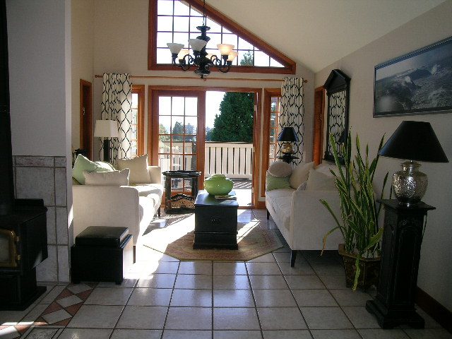 Spacious living room with large windows, tiled floor, and a cozy seating area. - 2148 Kings Ave, West Vancouver