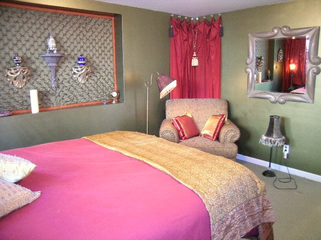 Spacious bedroom with pink bedding, ornate mirror, and red curtains. - 2148 Kings Ave, West Vancouver