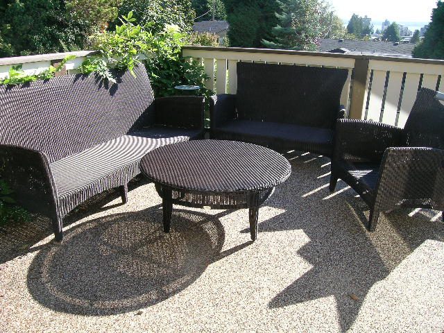 Outdoor patio with wicker furniture and a view of greenery. - 2148 Kings Ave, West Vancouver