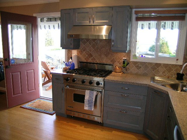 Bright kitchen with hardwood floors, granite countertops, and a city view through the window. - 875 Whitchurch Street, North Vancouver