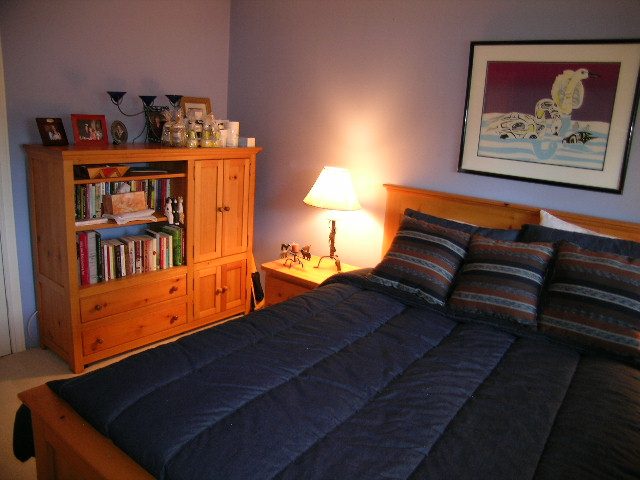 Bedroom with wooden furniture, framed artwork, and a cozy ambiance. - 875 Whitchurch Street, North Vancouver