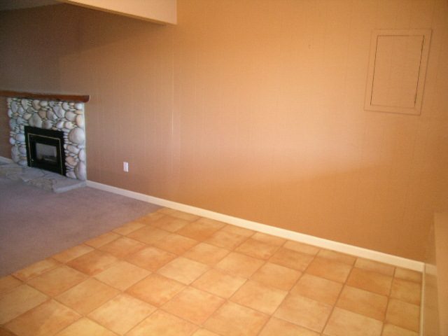 Living room with tiled floor and stone fireplace. - 875 Whitchurch Street, North Vancouver
