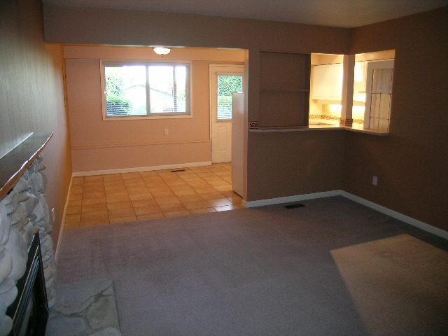 Living area with tiled floor and carpeted stairs leading to a kitchen. - 875 Whitchurch Street, North Vancouver