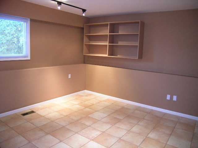 Bright living room with built-in shelves and tiled flooring. - 875 Whitchurch Street, North Vancouver