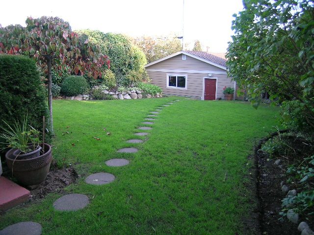 Landscaped backyard with stepping stones and a small shed. - 875 Whitchurch Street, North Vancouver