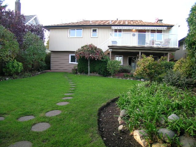 Spacious backyard with stepping stones and lush greenery. - 875 Whitchurch Street, North Vancouver