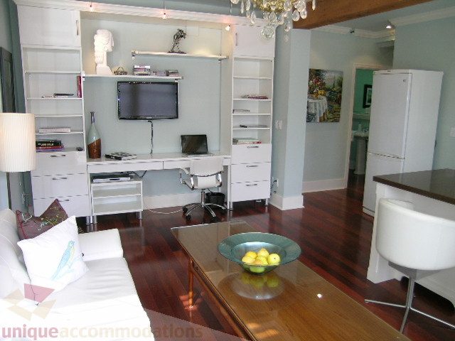Bright living room with hardwood floors, modern furniture, and a kitchen counter. - 45 - 777 Burrard Street, Vancouver Downtown