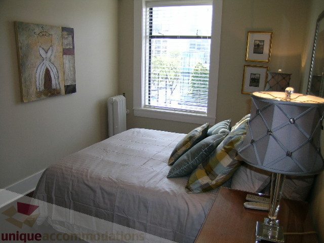 Bright bedroom with large window, city view, and modern decor. - 45 - 777 Burrard Street, Vancouver Downtown