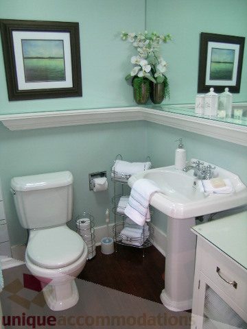 Furnished bathroom with mint green walls, white sink, and glass countertop. - 45 - 777 Burrard Street, Vancouver Downtown