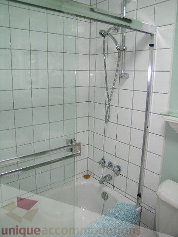 Furnished bathroom with white tiles, bathtub, and shower. - 45 - 777 Burrard Street, Vancouver Downtown